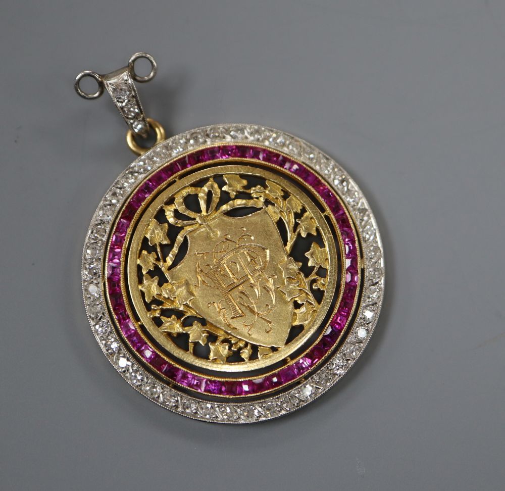 An early 20th century pierced yellow metal, ruby and diamond set circular pendant, 30mm gross 8.1 grams,